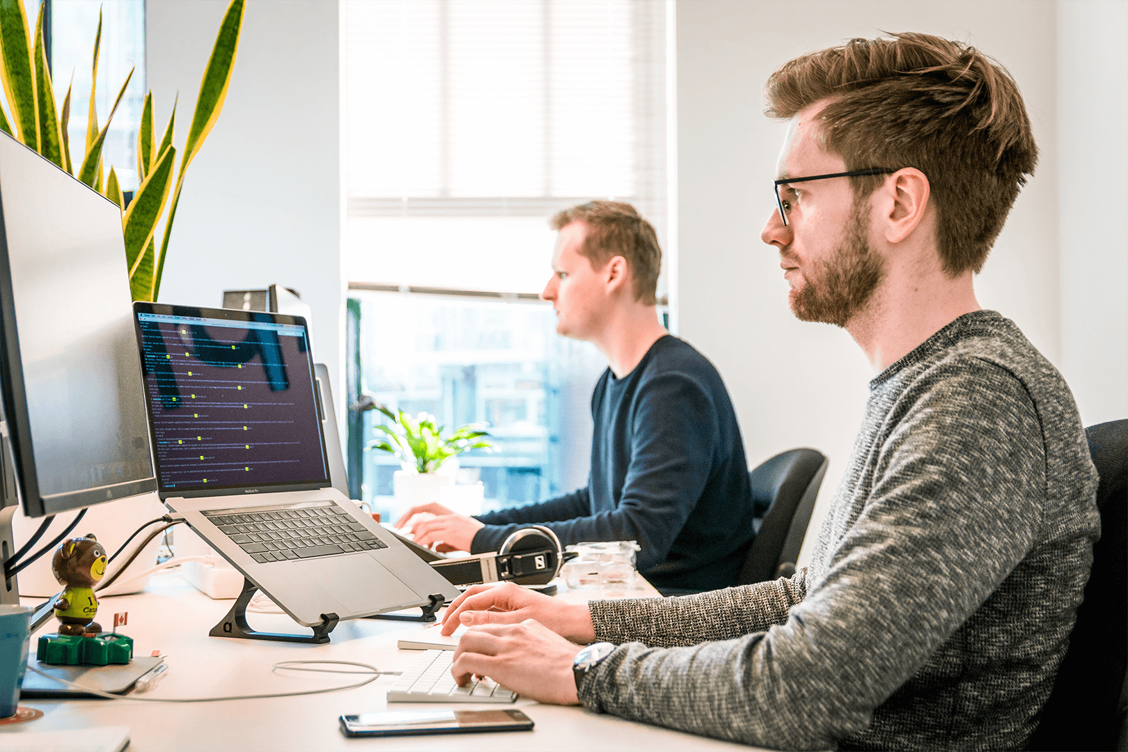 2 men using laptops in office